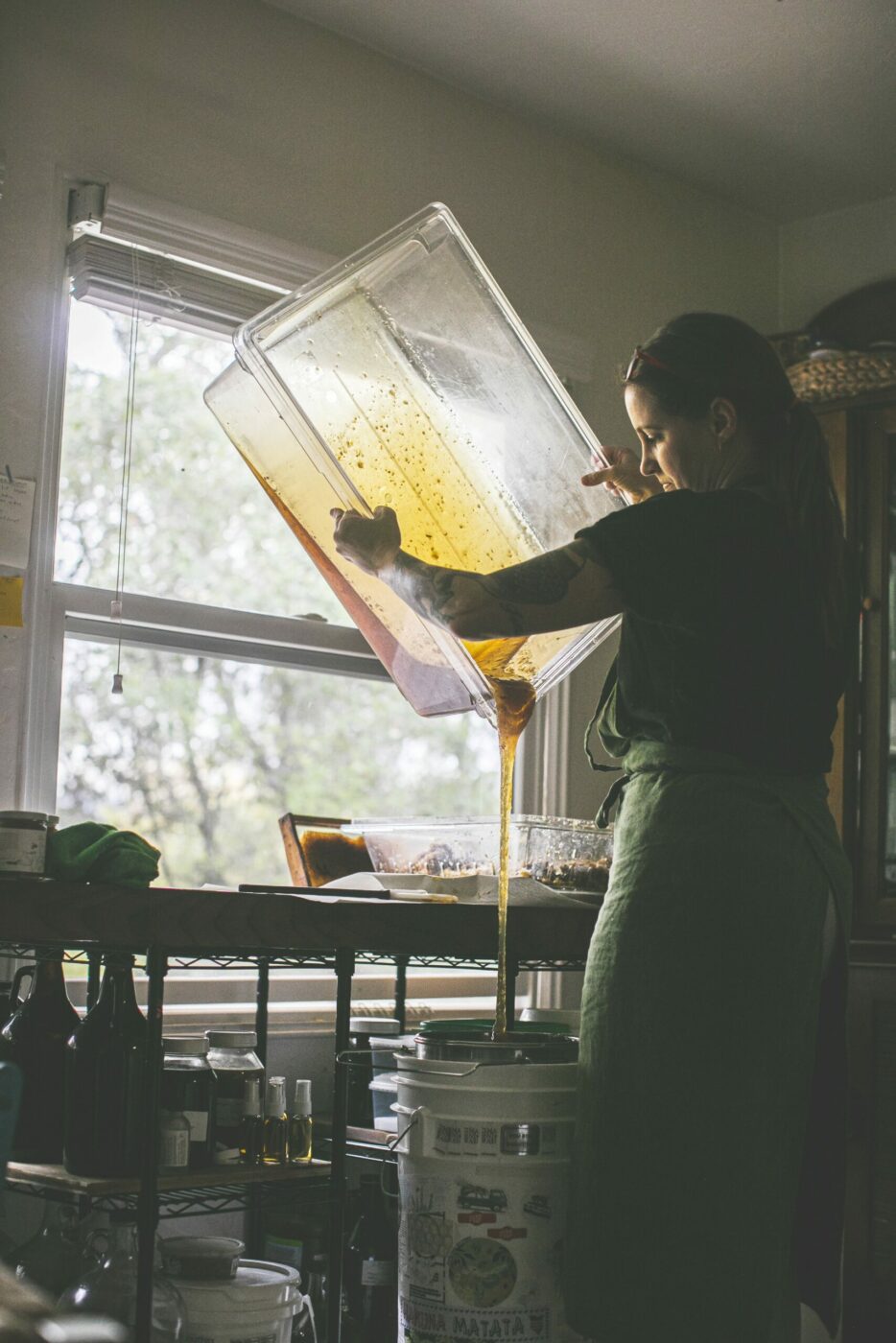 Sonoma beekeeper Candice Koseba strains honey