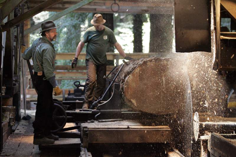 Harvey Henningsen, left, and Ron Sturgeon run a log through the blades of hte headrig at Sturgeon's Mill.
